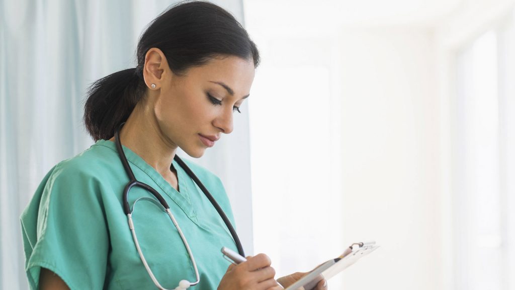 healthcare provider writing on clipboard