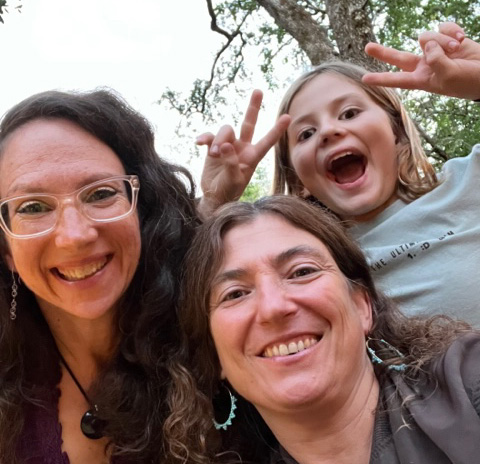 Smiling person with two other smiling loved ones