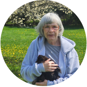 Person in an orchard holding a chicken